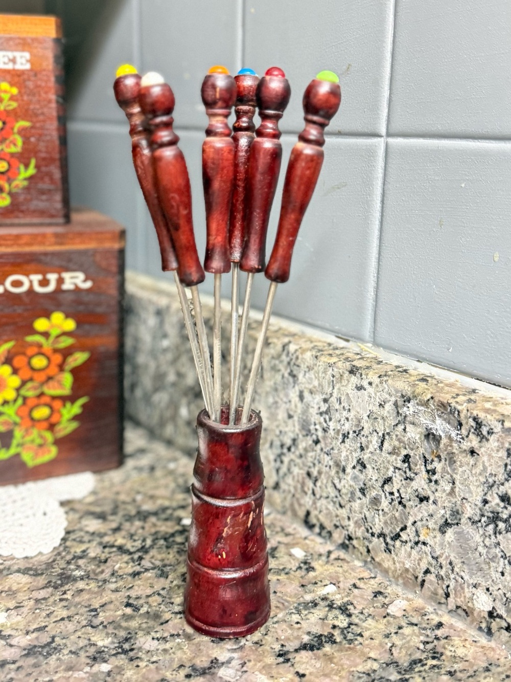 Mcm vintage fondue forks featuring reddish wood handles and colored tips.
